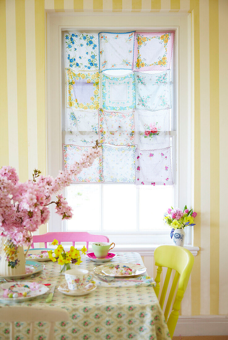 Genähte Taschentücher am Fenster mit einem für Ostern gedeckten Tisch