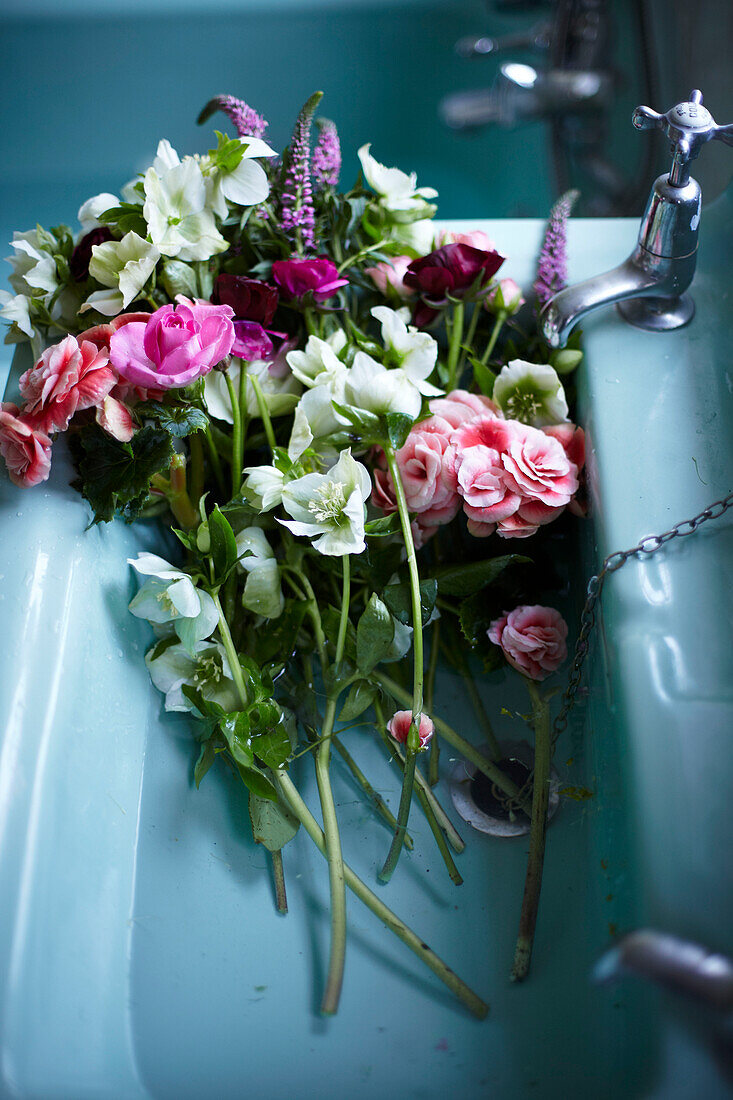 Vintage Blooms Schnittblumen in einem türkisfarbenen Waschbecken