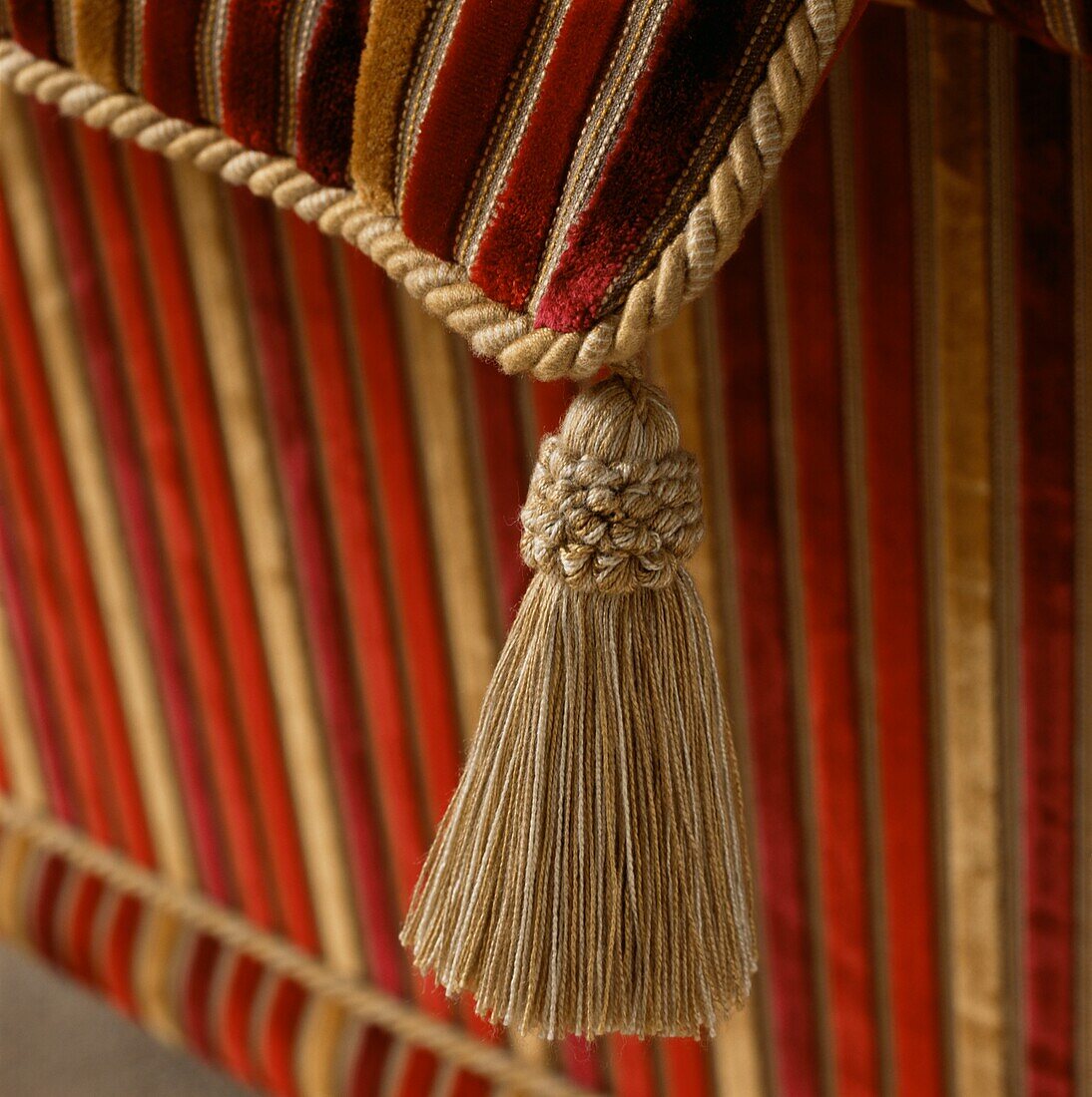 Detail of a gold coloured tassel on a cushion