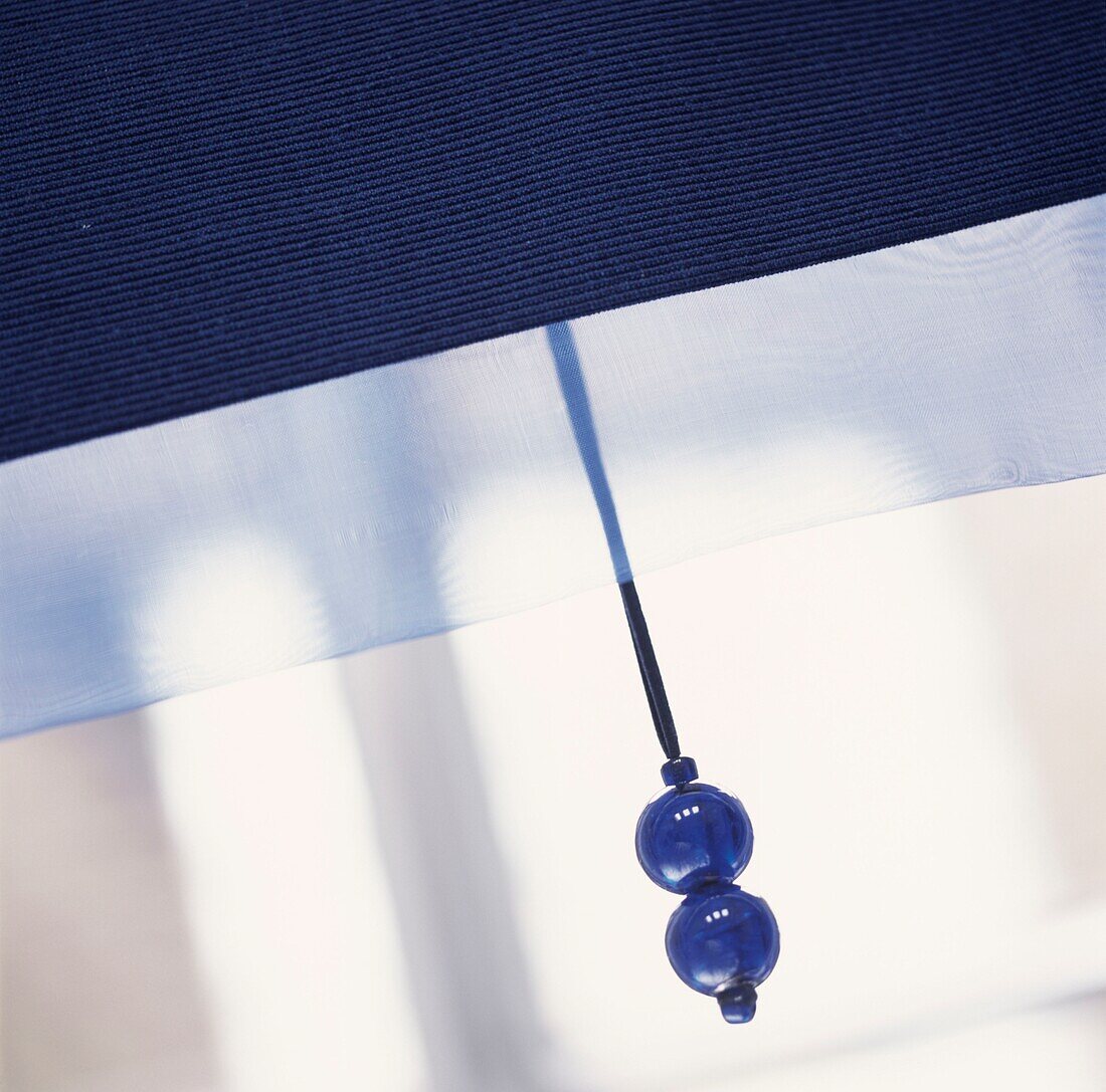 Blue beaded blind pull on a window blind
