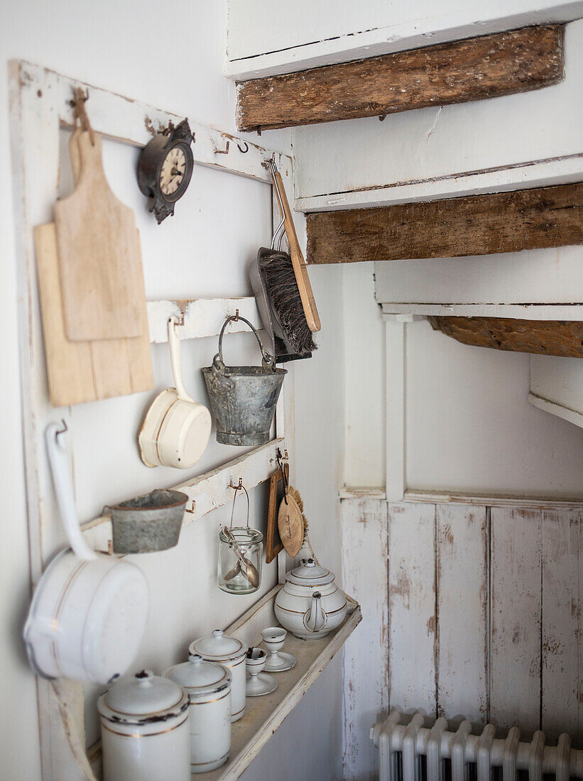 Understairs storage with vintage boards hanging pots pans and brushes
