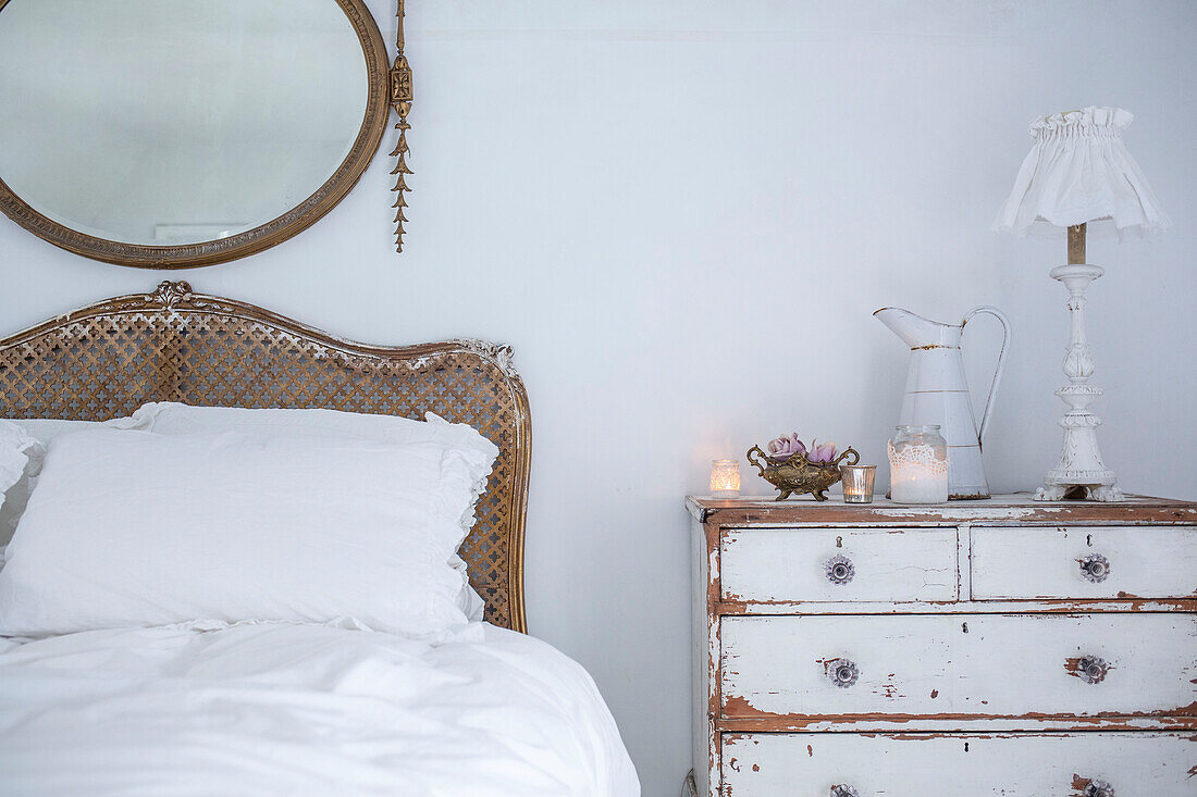 Scandinavian style bedroom with distressed paintwork and vintage bed and chest of drawers