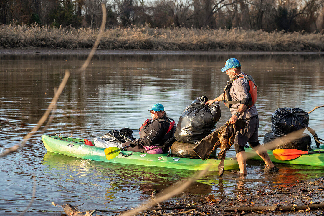 Volunteers collecting trash along Anacostia River, USA