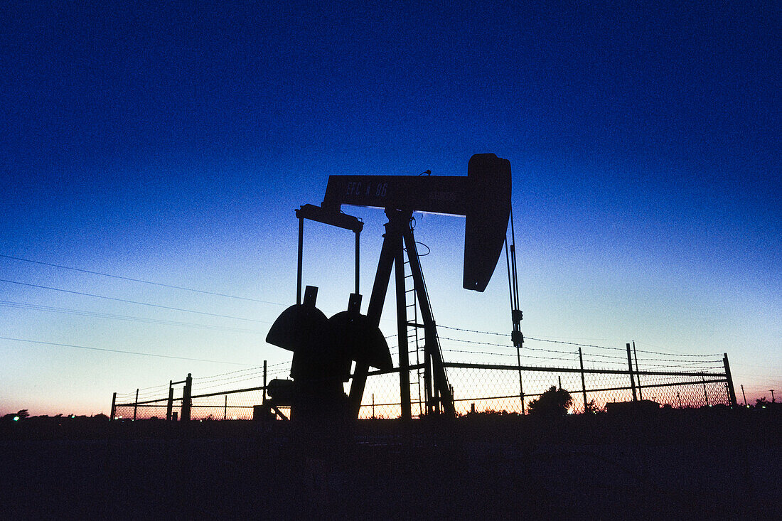 Silhouette of an oil field pumpjack at sunset