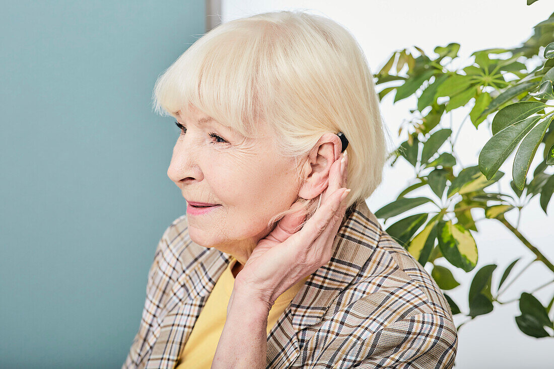 Woman adjusting hearing aid