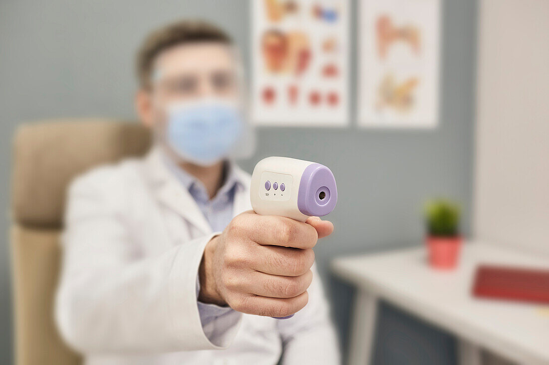 Doctor using infrared thermometer
