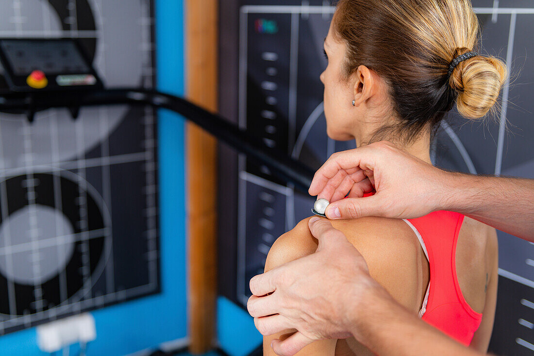 Technician placing markers on athlete's shoulder