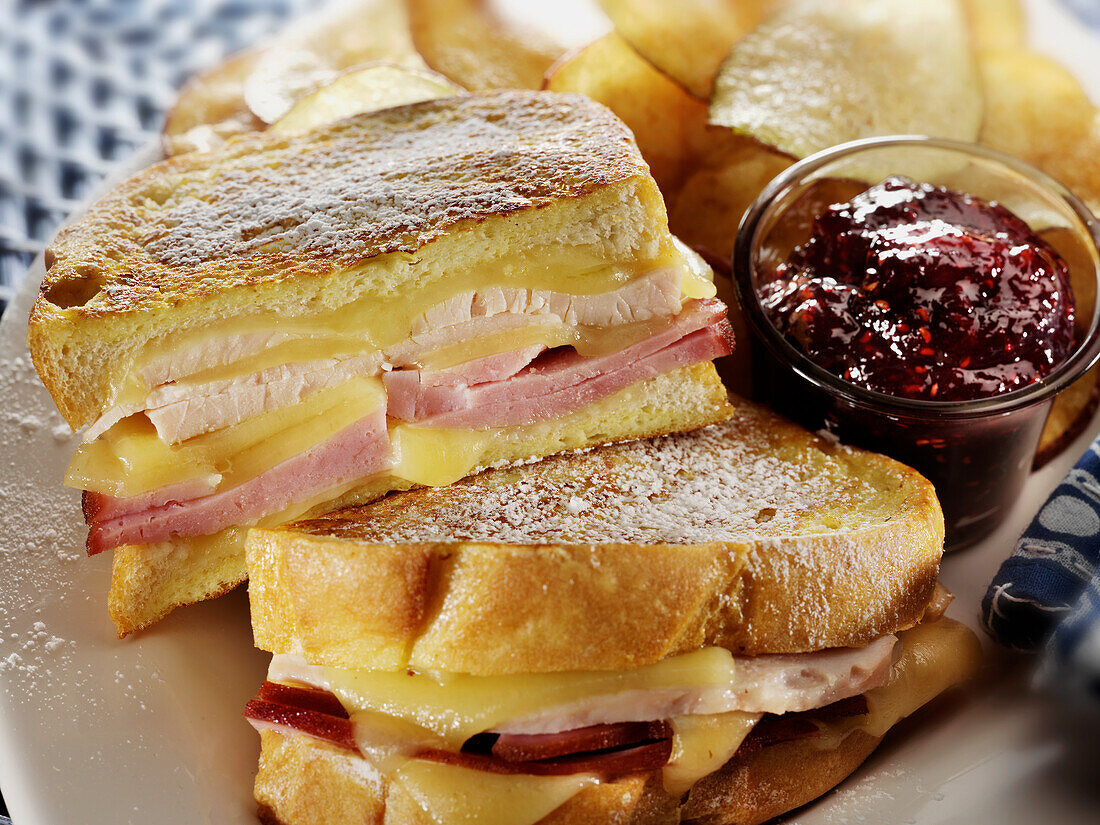 Monte Cristo-Sandwich mit Putenschinken und Schweizer Käse, Himbeermarmelade und Kartoffelchips