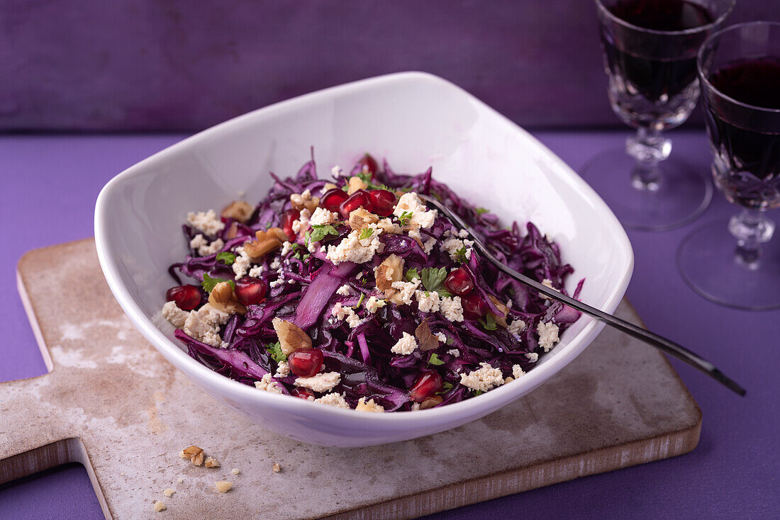 Vegan red cabbage salad with tofu, pomegranate seeds, and walnuts