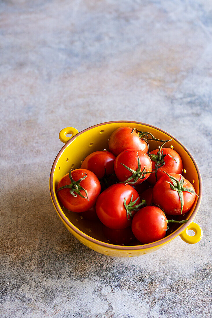 Organic Vine Tomatoes in Yellow Ceramic Colander