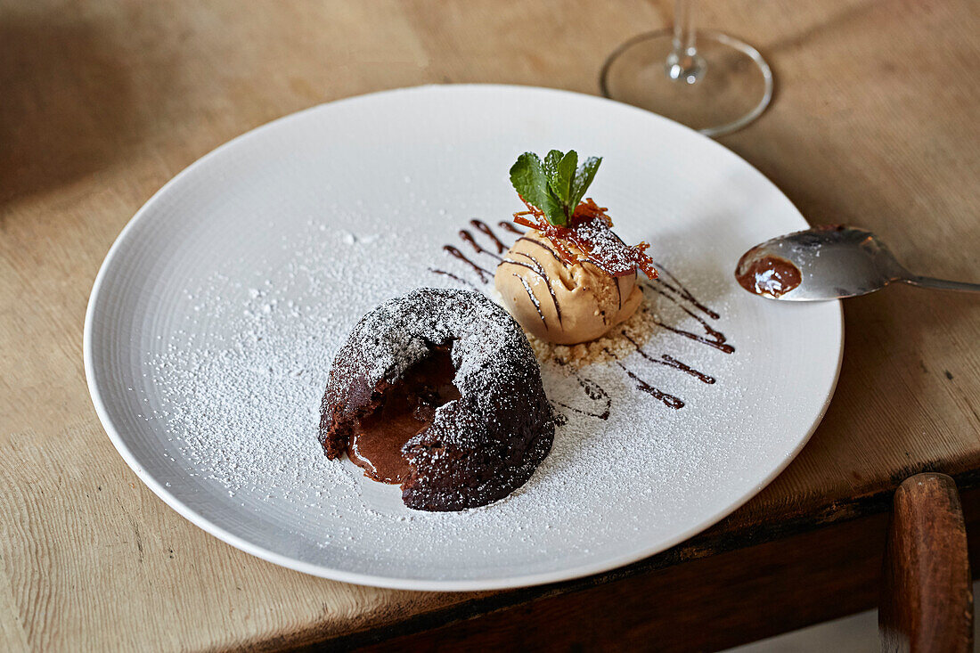 Schokoladenpudding mit flüssigem Kern serviert mit gesalzenem Karamelleis