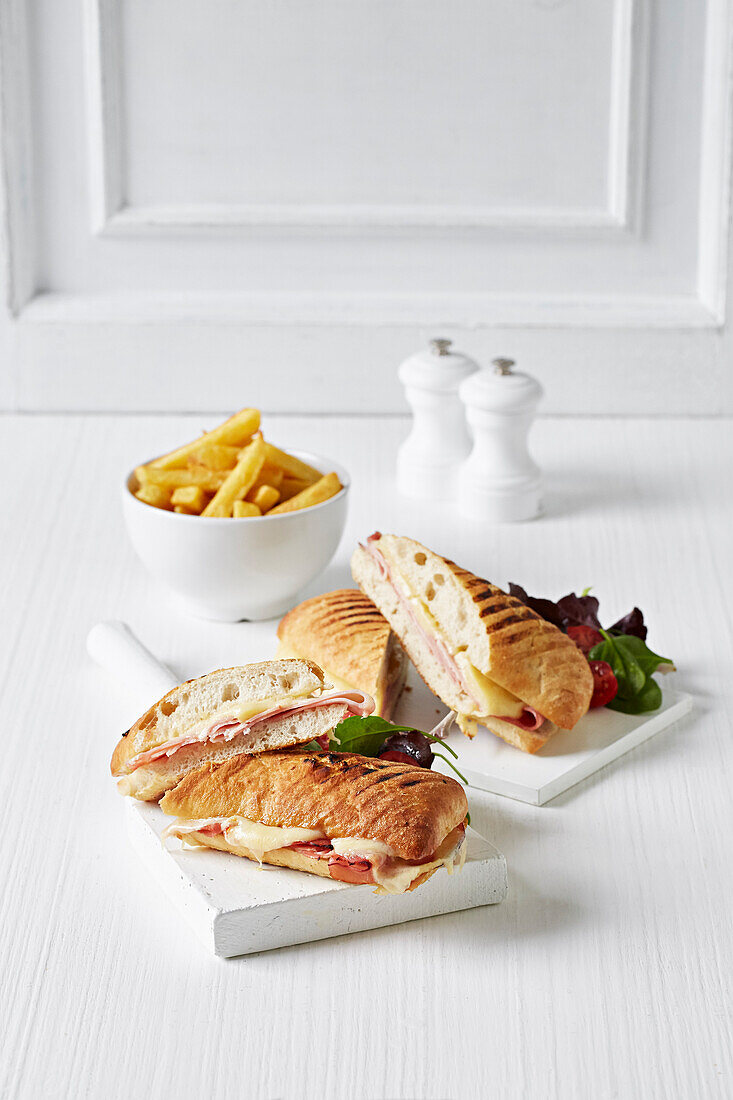 Panini mit Schinken und Käse serviert mit Pommes frites