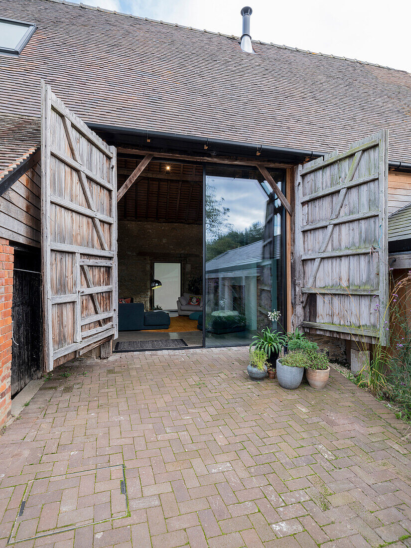 A former banr - exterior view of large barn door and sliding glass door