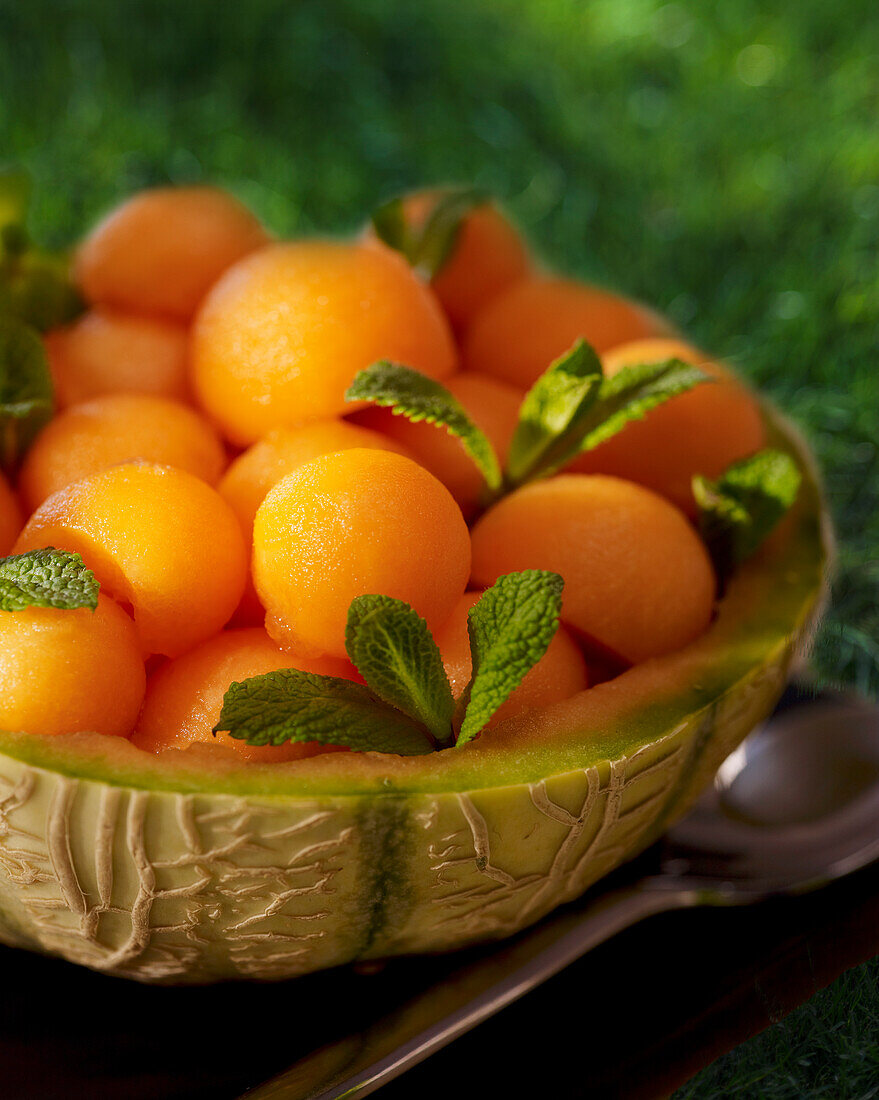 Melon balls with pastis and mint in hollowed melon