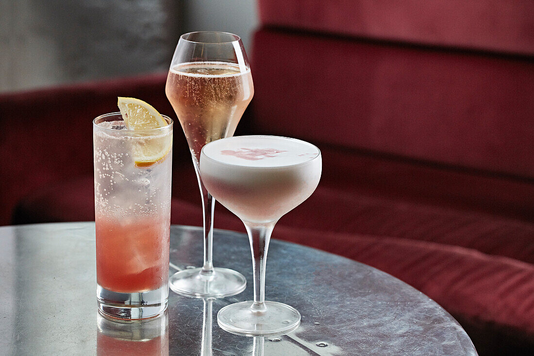 Drei Cocktails auf rundem Tisch