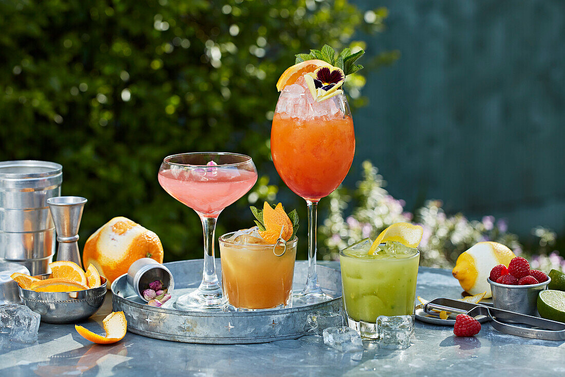 A table outside with four summer cocktails