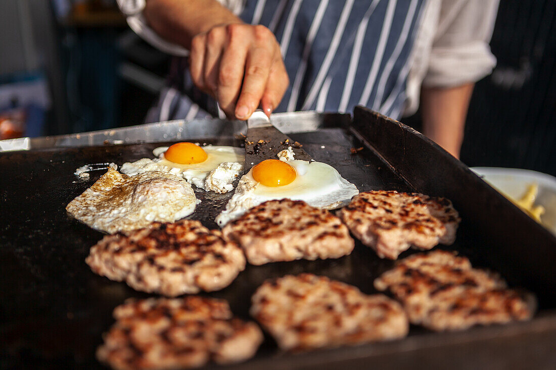 Burgerpatties und Spiegeleier auf dem Grill