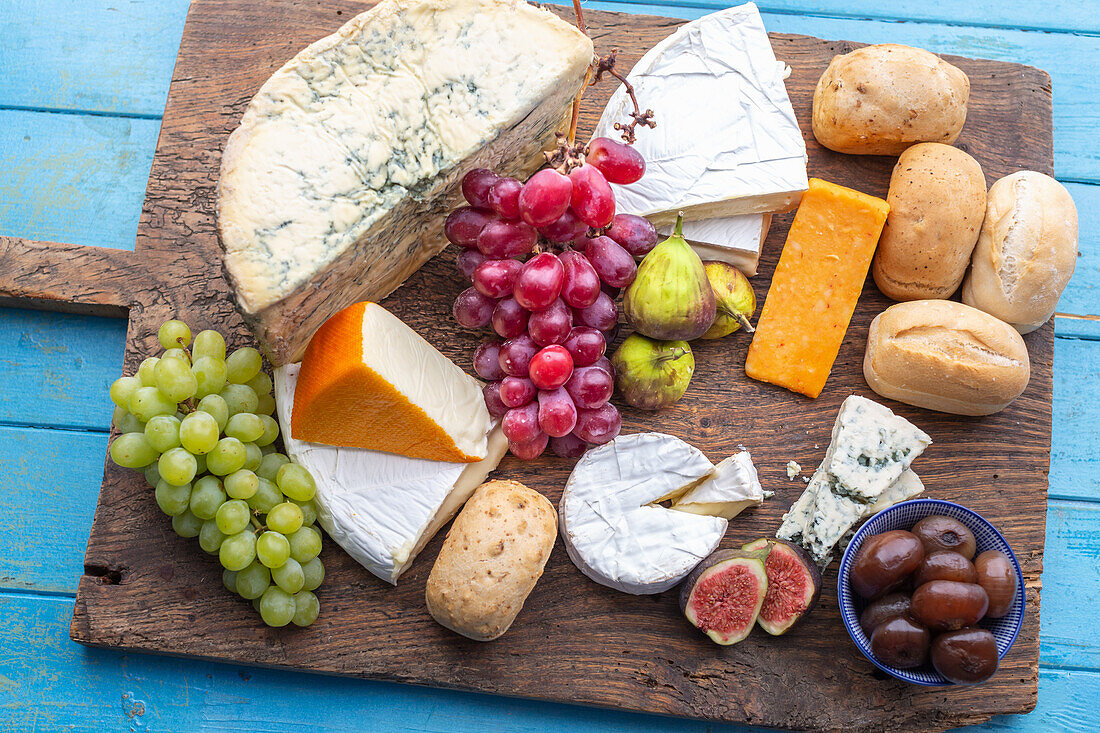 Cheese board with buns, figs, grapes and pickled onions