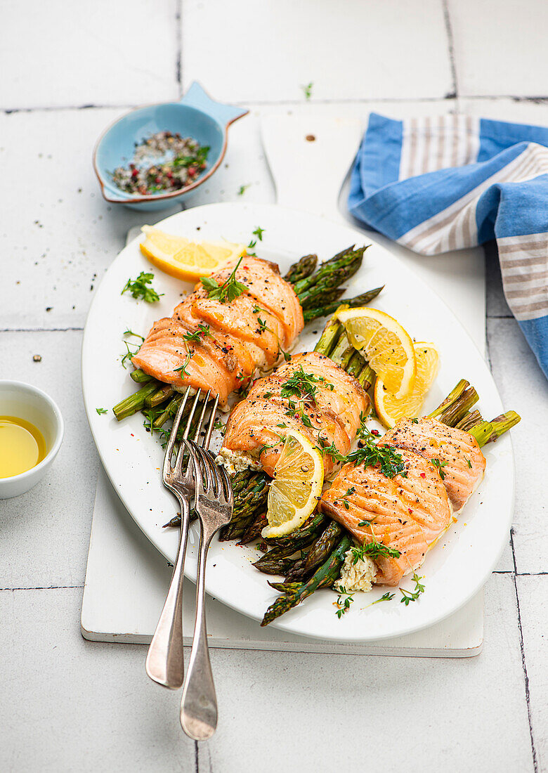 Salmon trout rolls with curd cheese filling and green asparagus