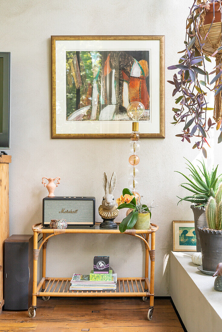 Serving trolley as side table with decorative objects and plant