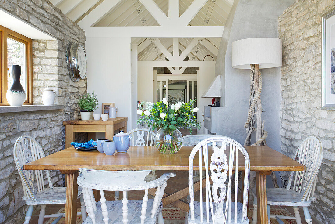 Esszimmer im Landhausstil mit Natursteinwand und Holzmöbeln