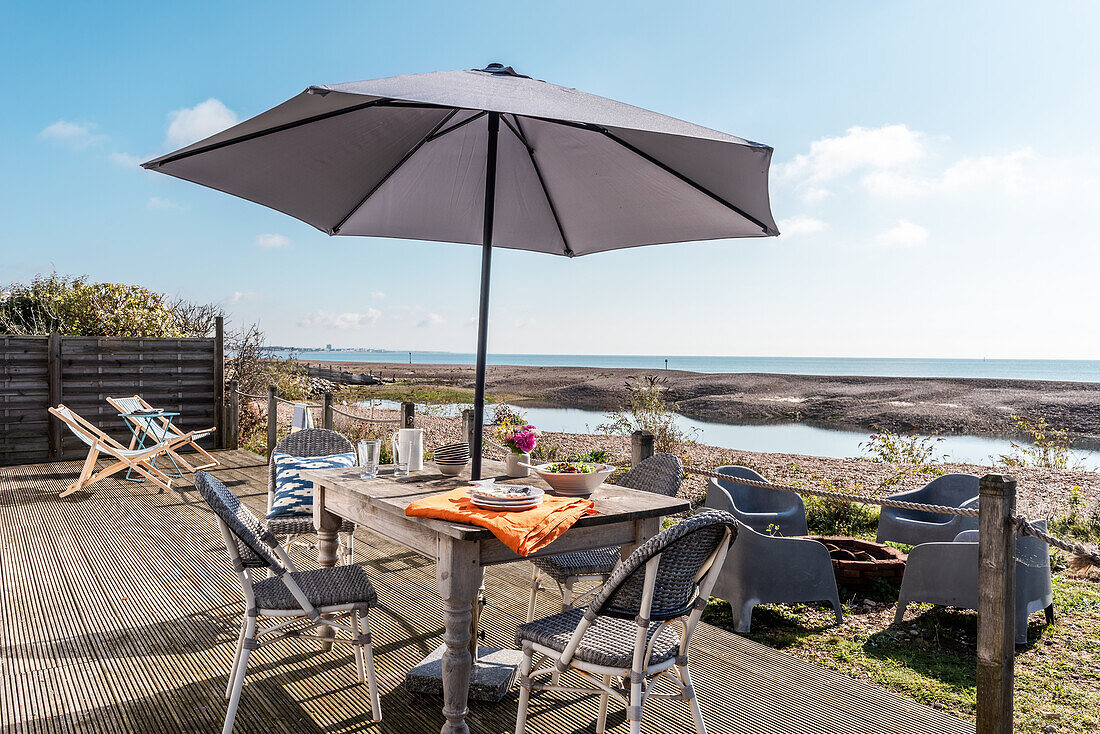 Terrace with dining area and sun umbrella with sea view