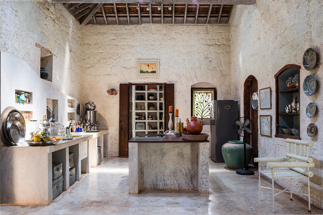 Rustic-style kitchen with exposed beams and plastered stone walls