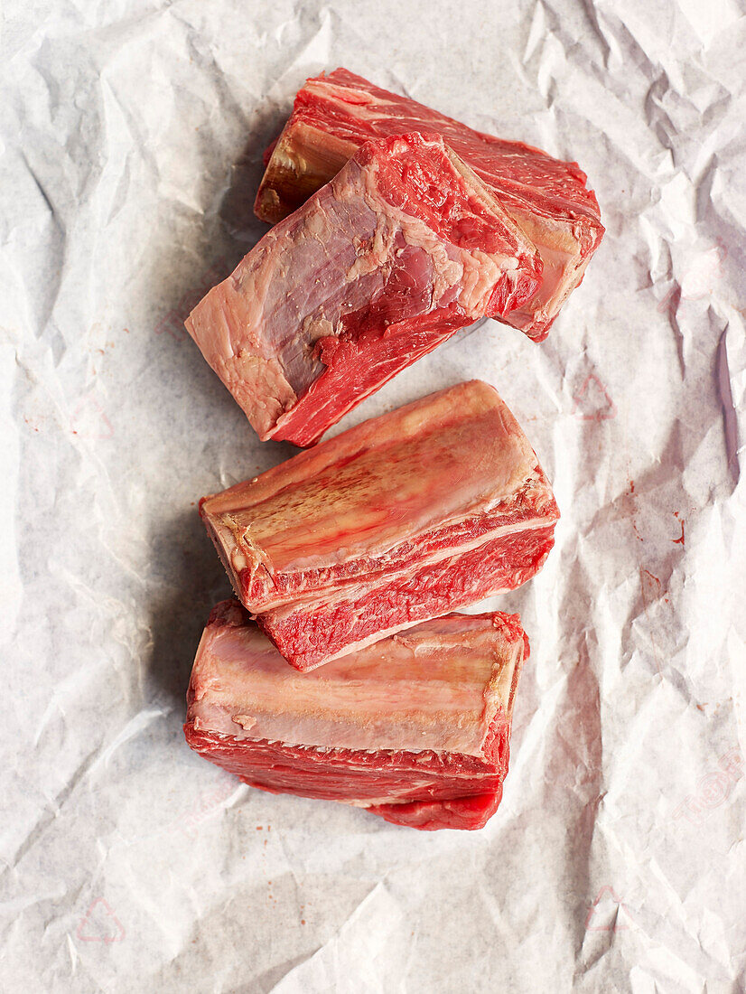 Raw beef short ribs on paper