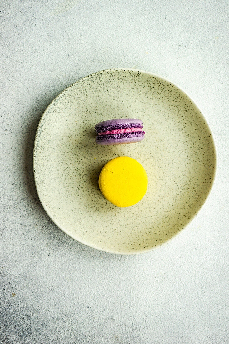Close up of lavender and lemon macaroons on white concrete background