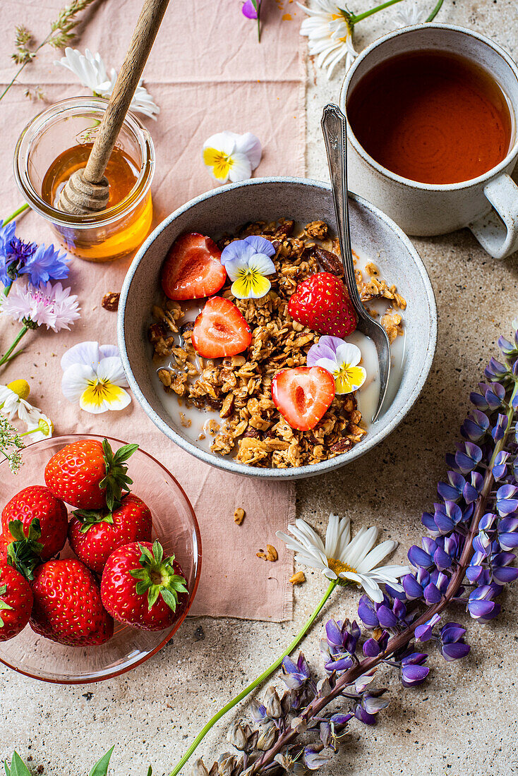 Almond Granola served with honey and strawberries and tea