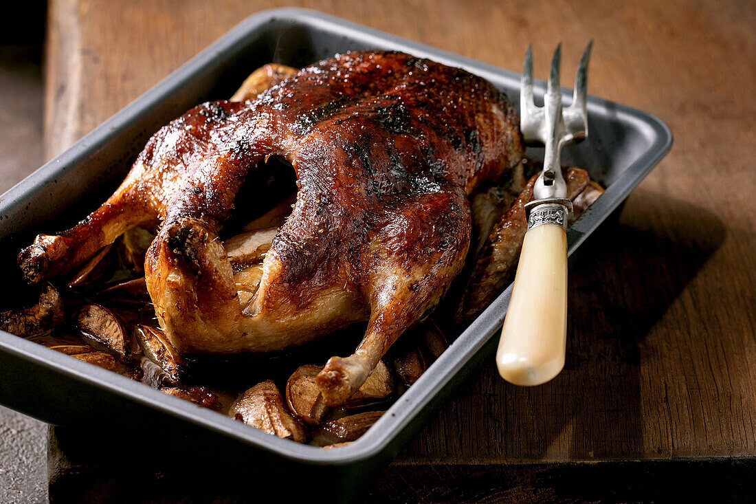Classic holiday dish roasted glazed duck with apples in baking tray