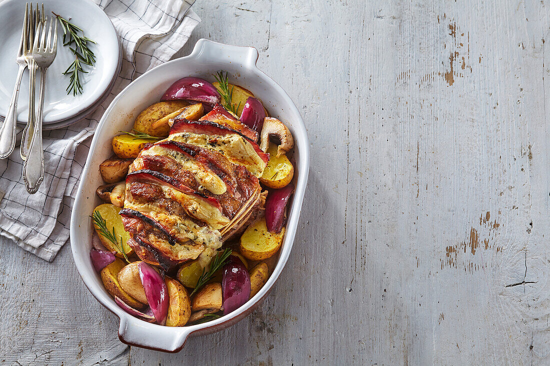 Stuffed pork collar with roast potatoes and red onions