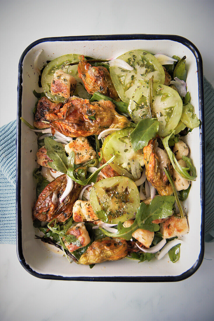 Stuffed zucchini flowers with green tomatoes and rocket salad