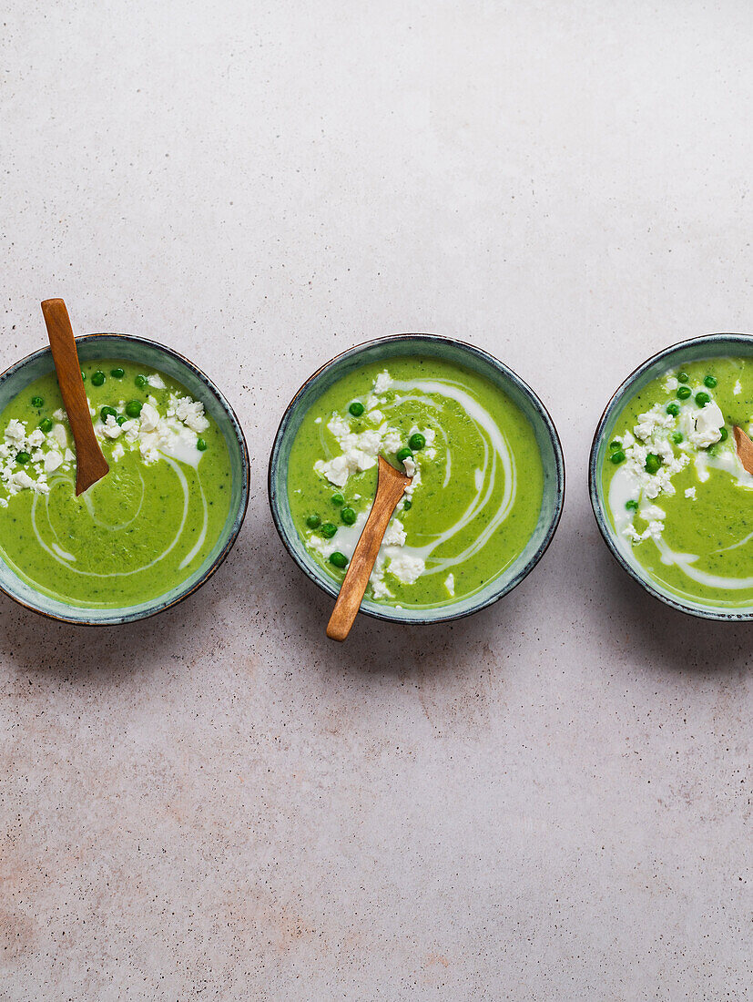 Pea cream soup in bowls served on table