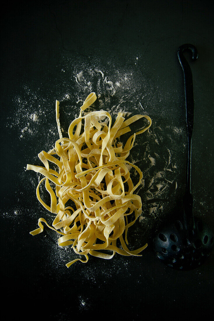 Selbstgemachte Tagliatelle auf dunklem Untergrund