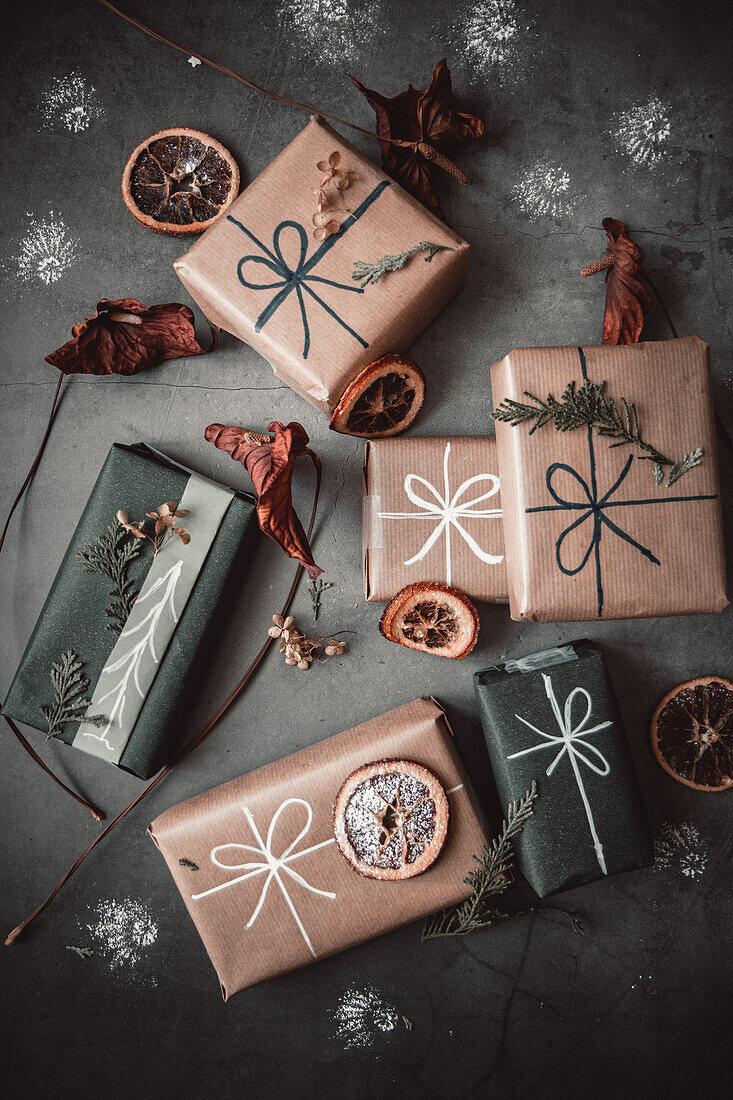 Verpackte Weihnachtsgeschenke dekoriert mit getrockneten Blutorangenscheiben