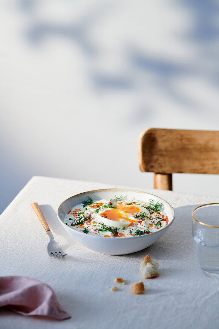 Ceramic bowl with Turkish Eggs - Cilbir - placed on table