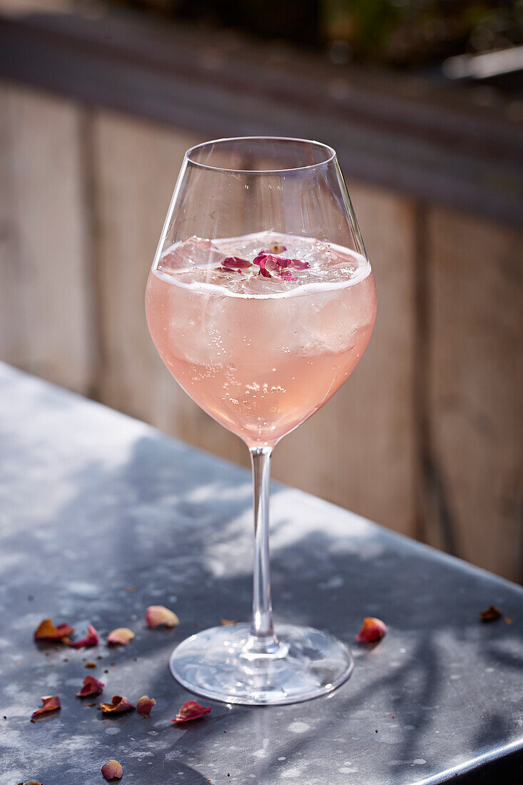 A summer berry drink decorated with rose petals