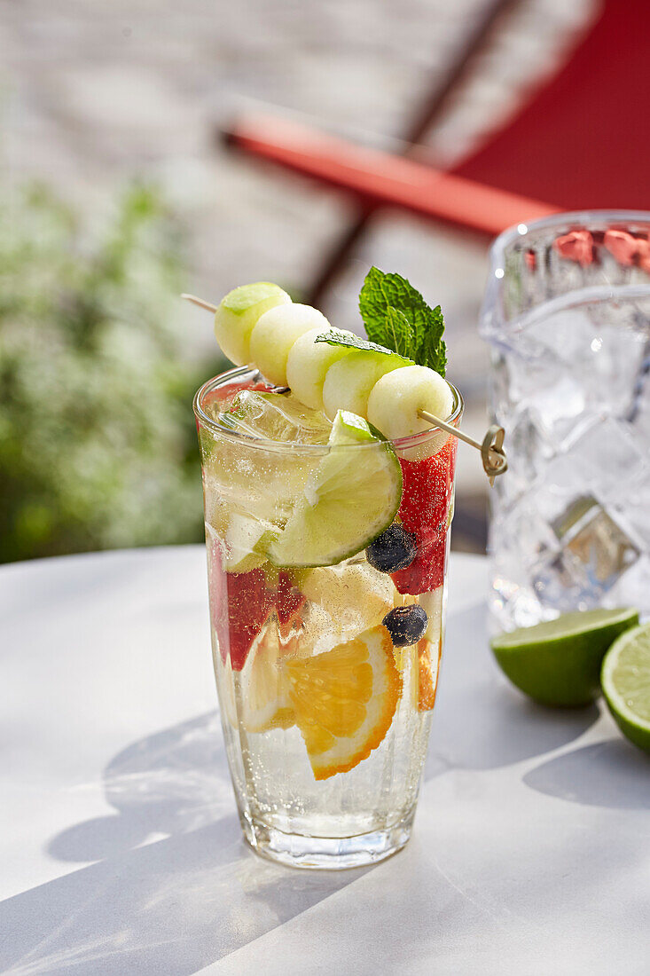 Erfrischendes, fruchtiges Sommergetränk mit Früchten und Melonenspießchen
