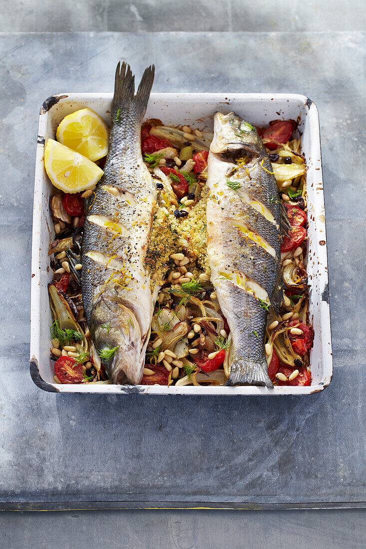 Ganze, gefüllte, gebratene Fische auf Fenchel-Tomaten-Gemüse