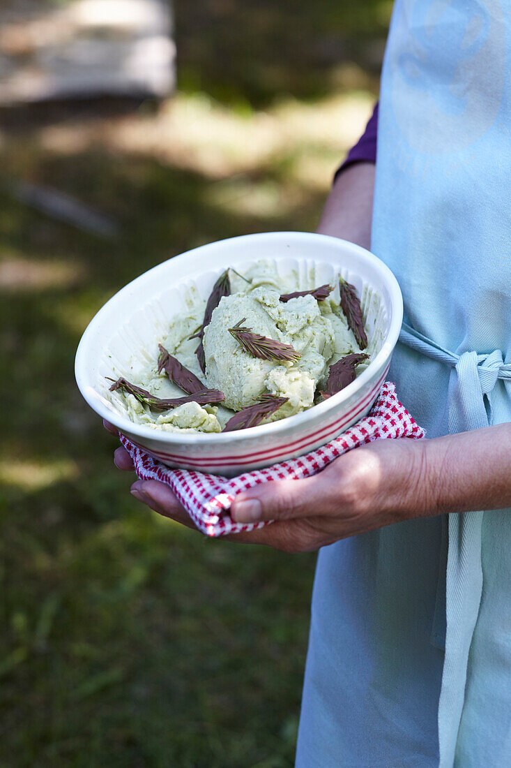 Spruce tip ice cream garnished with chocolate spruce tips in a bowl