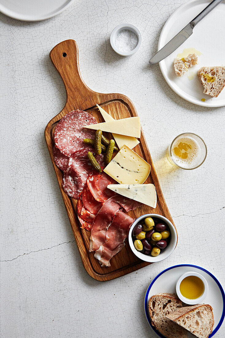Charcuterie, cheese, pickles and olives on a board