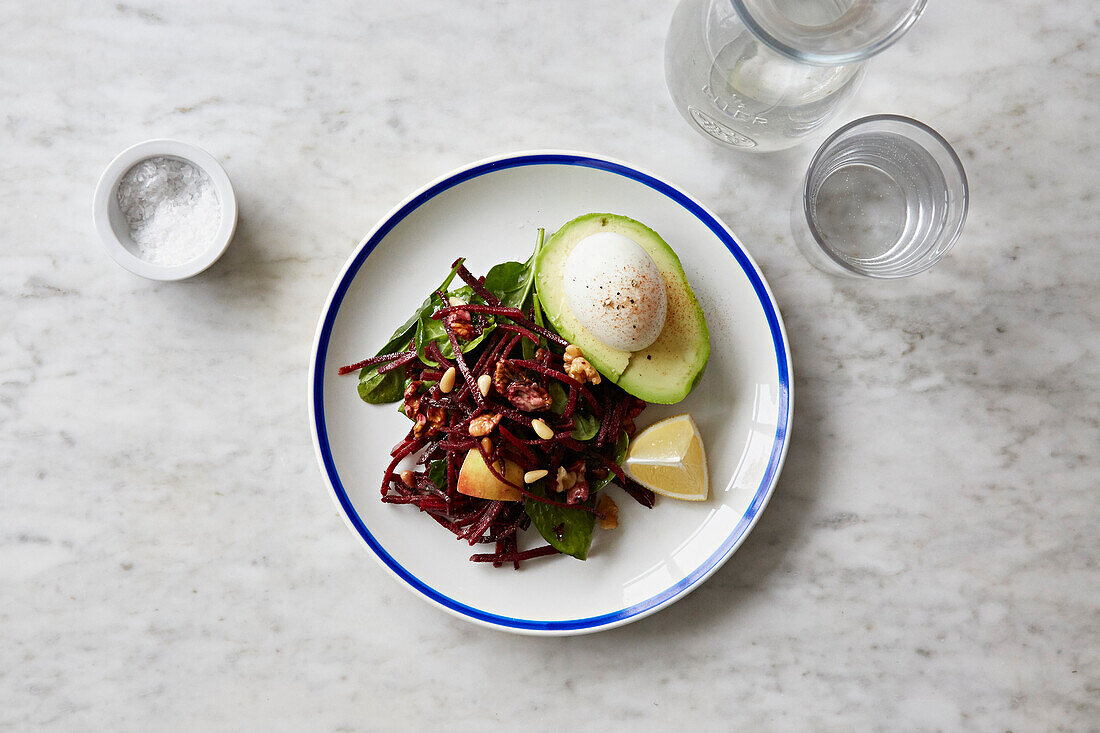 Avocado topped with a poached egg with a Spinach and pear salad