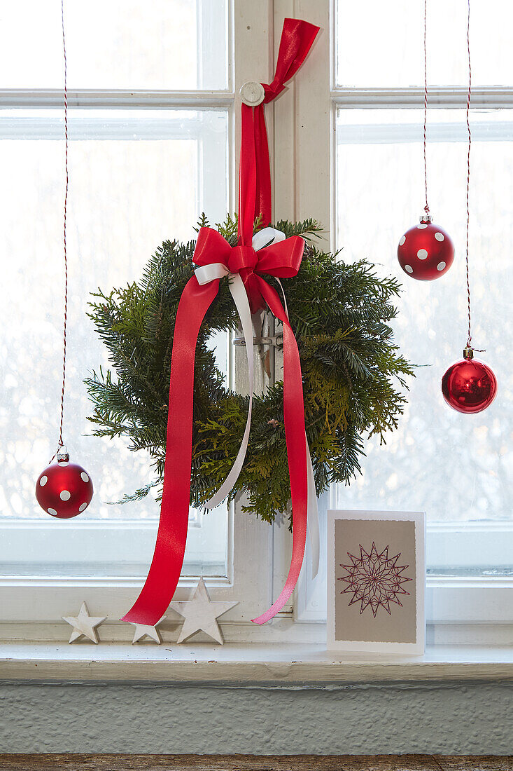 Weihnachtliche Fensterdeko mit Kranz und roten Kugeln