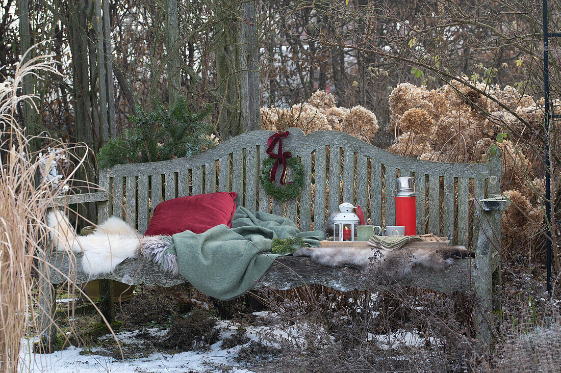 Gartenbank mit Fell, Kissen und Weihnachtsdekoration