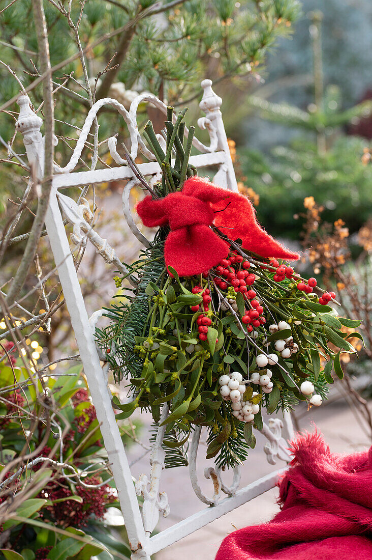 Weihnachtsstrauß mit Zweigen von der Nordmanntanne (Abies), Schneebeeren (Symphoricarpos), Mistelzweigen (Viscum album) und Ilexbeeren (Ilex verticillata)