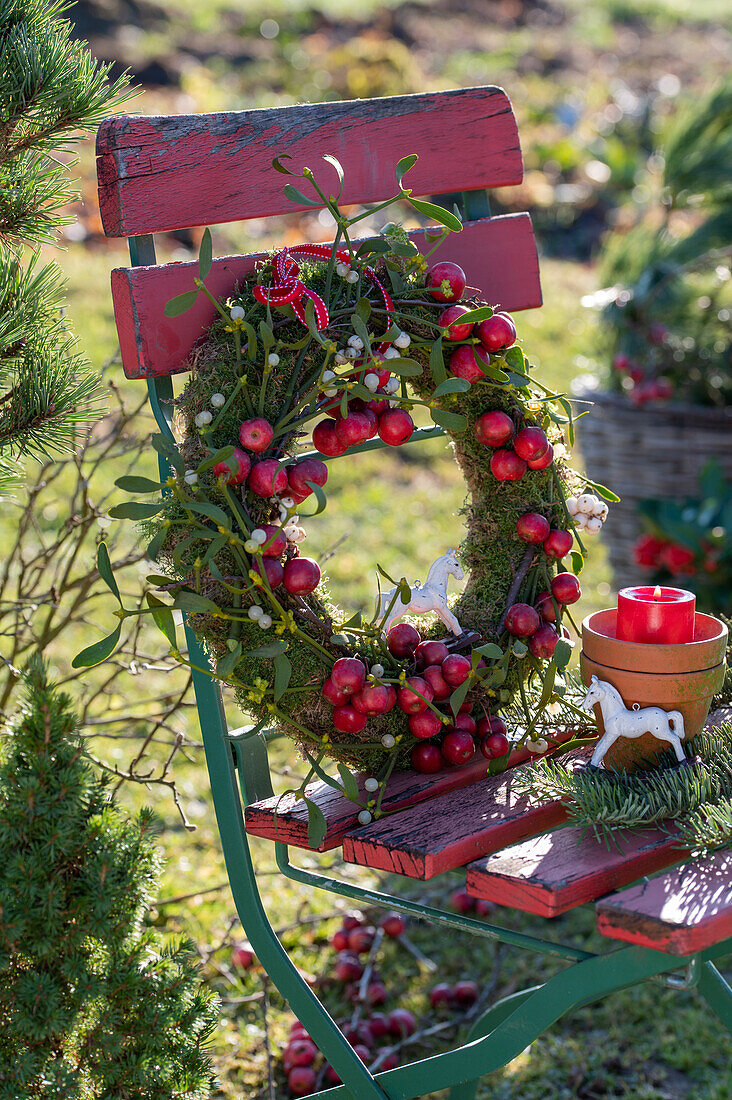 DIY wreath made of moss, ornamental apples, and mistletoe