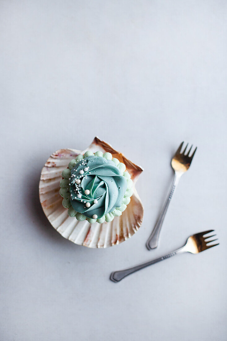 Monoportion cupcake with blue frosting in a clam shell
