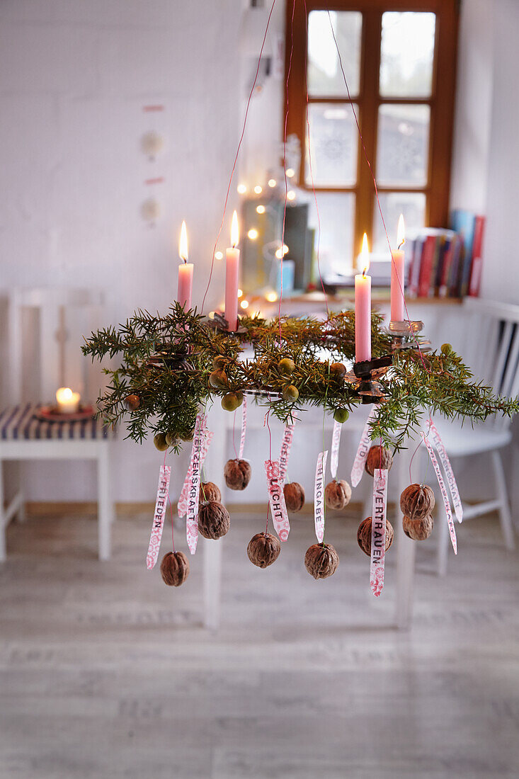 A juniper wreath with four candles, decorated with walnuts and wish lists