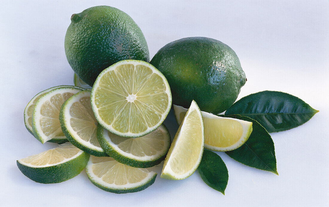 Still life with limes, lime quarters and lime slices